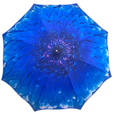 A large, vibrant blue flower-print umbrella with a dark purple patterned center, 