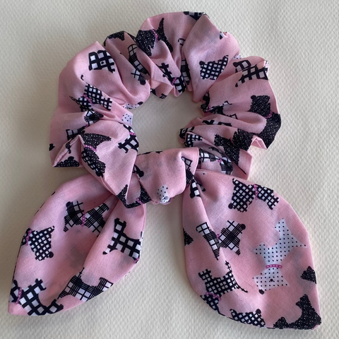 Pink scrunchie with black pattern on a light gray background