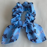 Blue scrunchie with black pattern on a light gray background