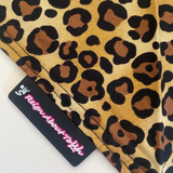 Leopard print fabric with a visible brand label on a white background