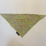 Floral patterned triangle-shaped fabric on a white surface with a brown border.