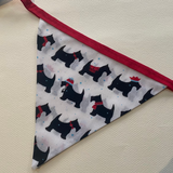 Triangle-shaped fabric with black dog pattern on a light background