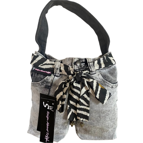 Handbag made from repurposed jeans with a zebra pattern ribbon and visible brand tag.