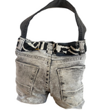 Denim jeans bag with a black strap on a white background.
