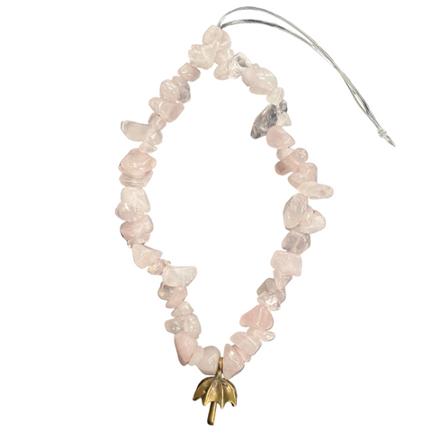 Rose quartz beaded phone strap
 on a dark surface.