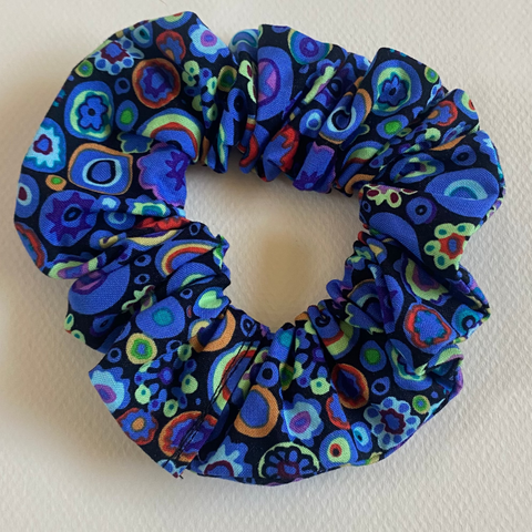 Blue patterned scrunchie on a light gray background