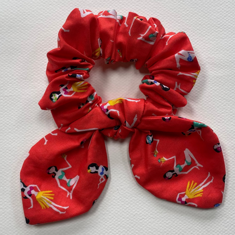 Red scrunchie with hula girl character pattern on a light gray background