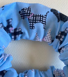 Blue headband with black and white dog pattern on a white background