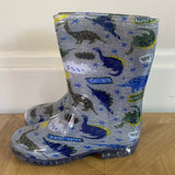 Wellington boot with dinosaur pattern on a wooden floor