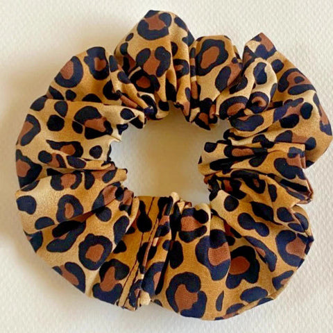 Leopard print scrunchie on a light beige background