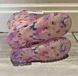 Pink butterfly-patterned shoes on a gray floor